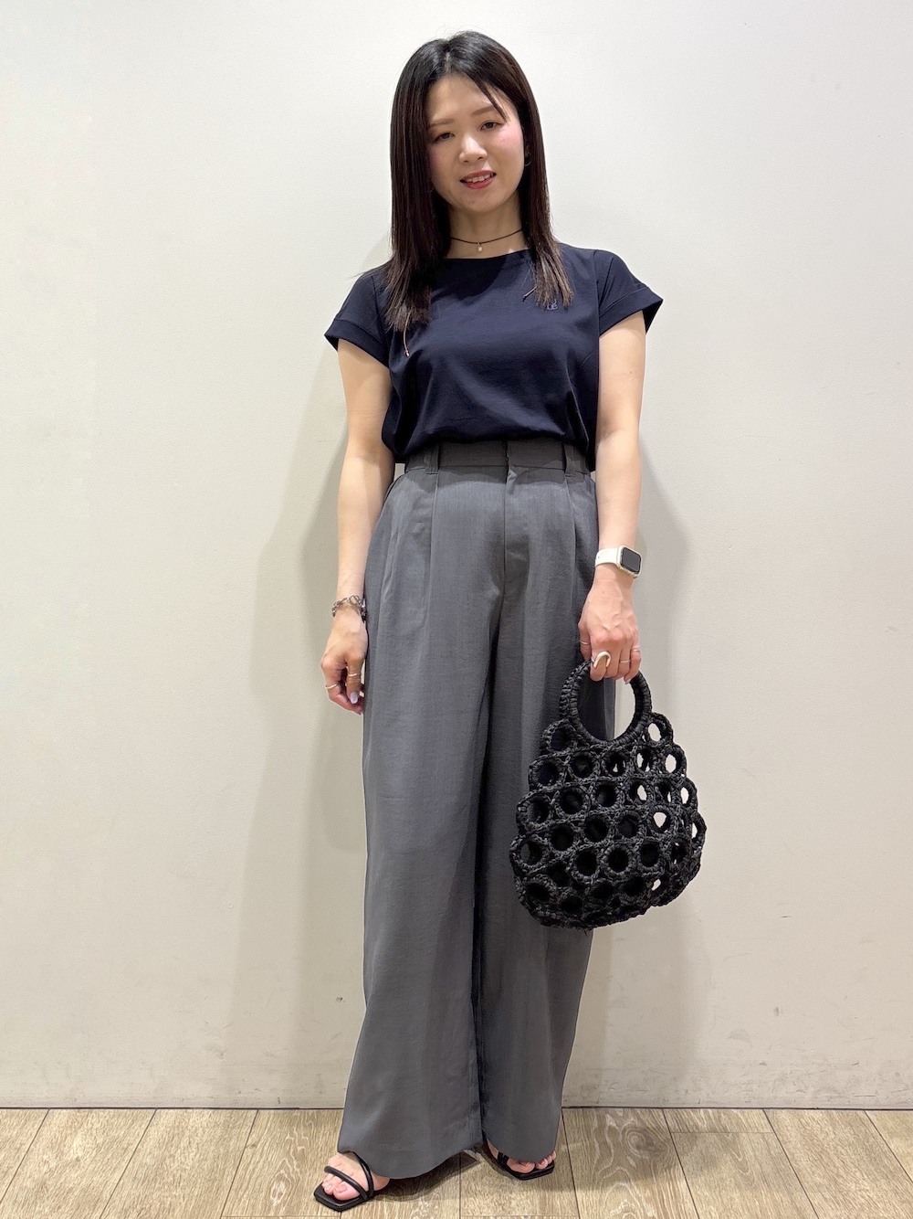ブルー系のTシャツ/カットソー、グレー系のその他パンツ、ブラック系のハンドバッグを着用したレディースの夏コーディネートの1枚目の写真