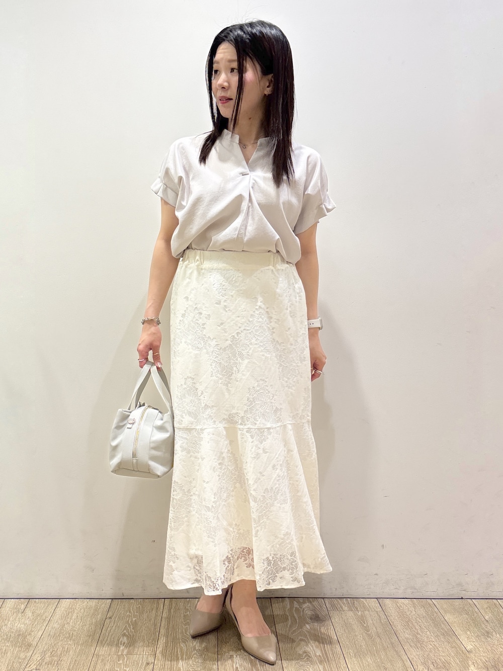ベージュ系のシャツ/ブラウス、ホワイト系のスカート、グレー系のボストンバッグを着用したレディースの夏コーディネートの1枚目の写真