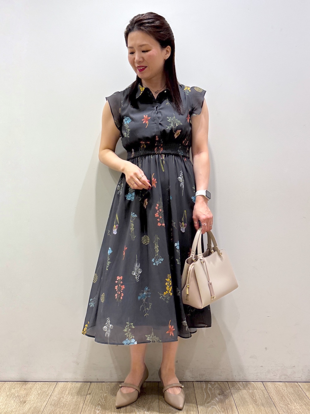 グレー系のワンピース、ベージュ系のボストンバッグ、ベージュ系のパンプスを着用したレディースの夏コーディネートの1枚目の写真