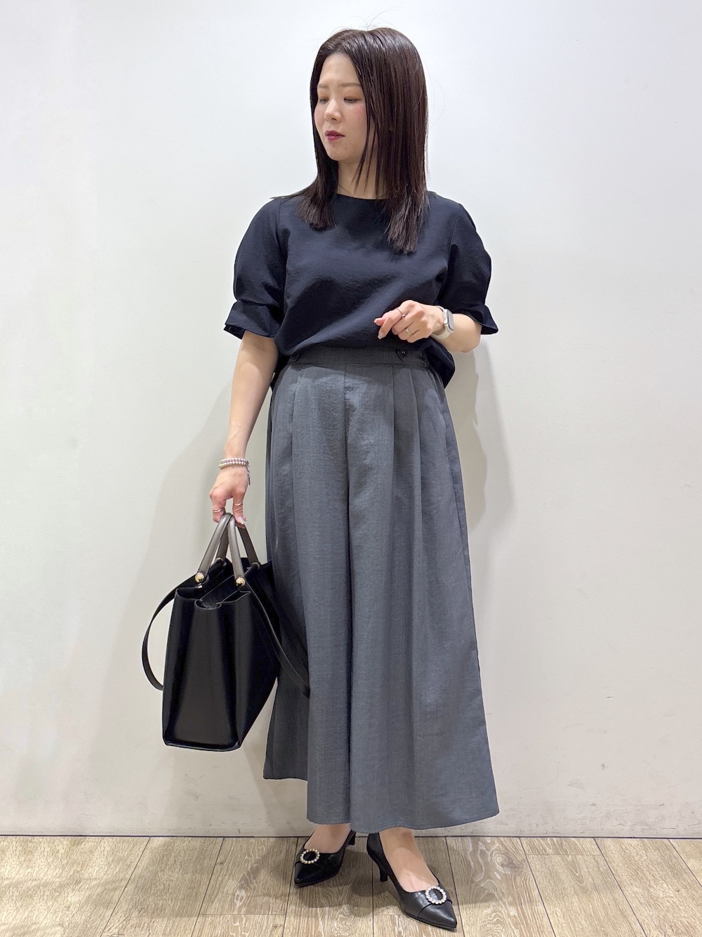 ブルー系のシャツ/ブラウス、グレー系のその他パンツ、ブラック系のトートバッグを着用したレディースの夏コーディネートの1枚目の写真