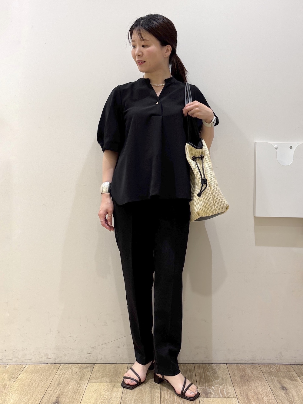 ブラック系のシャツ/ブラウス、ブラック系のその他パンツ、ブラウン系のサンダルを着用したレディースの春コーディネートの1枚目の写真