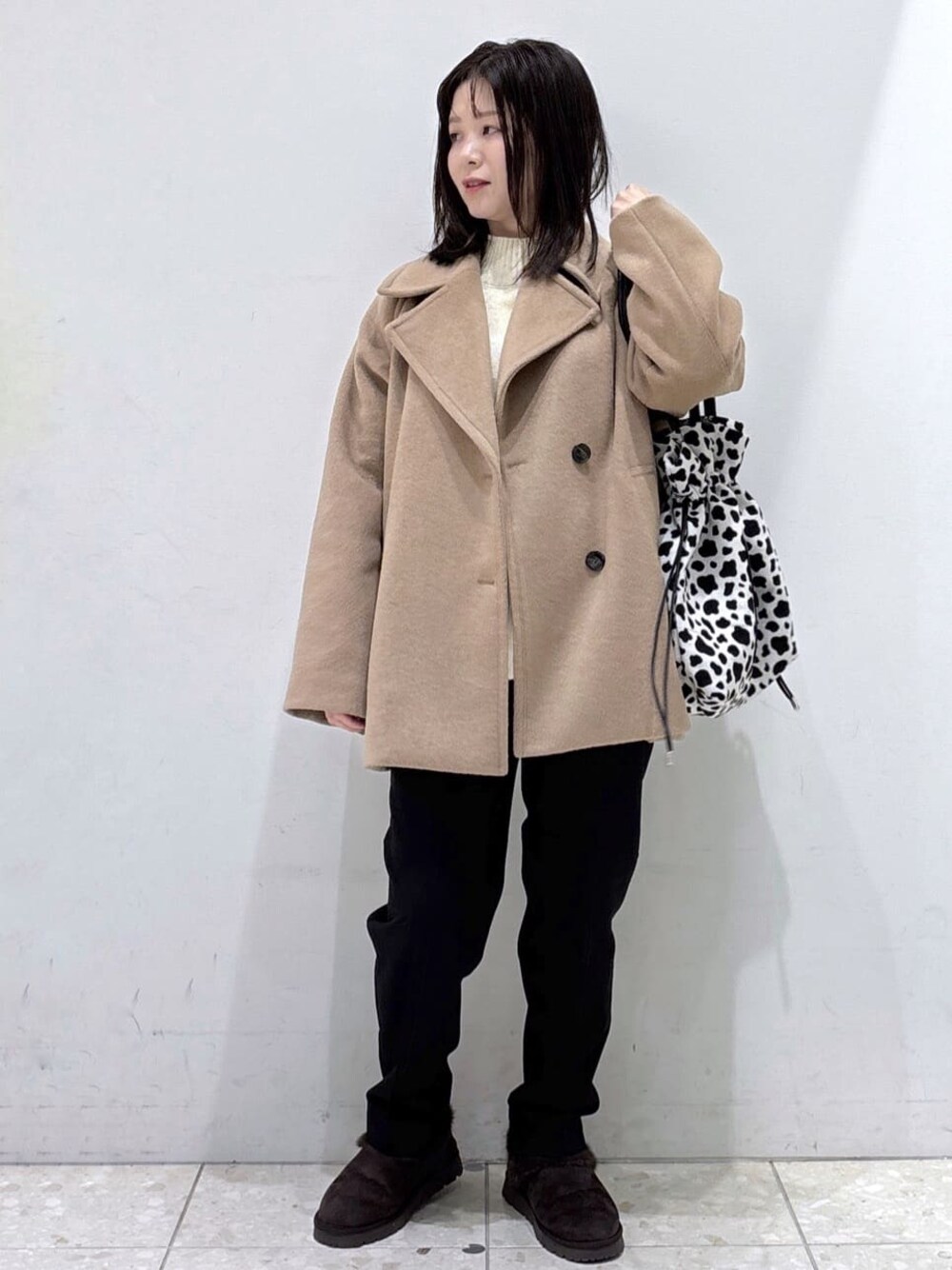 ベージュ系のピーコート、ベージュ系のニット/セーター、ブラック系のその他パンツを着用したレディースの冬コーディネートの1枚目の写真