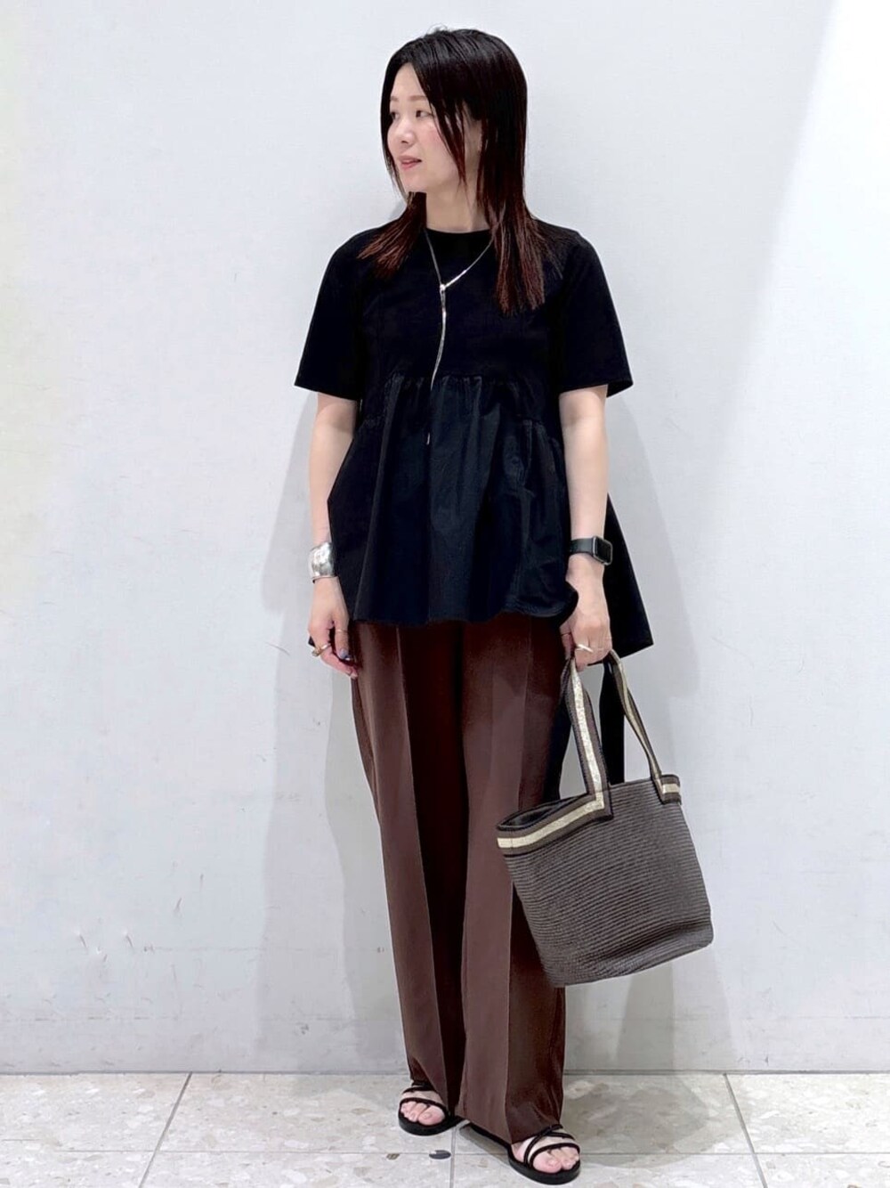 ブラック系のTシャツ/カットソー、ブラウン系のその他パンツ、ブラウン系のトートバッグを着用したレディースの夏コーディネートの1枚目の写真