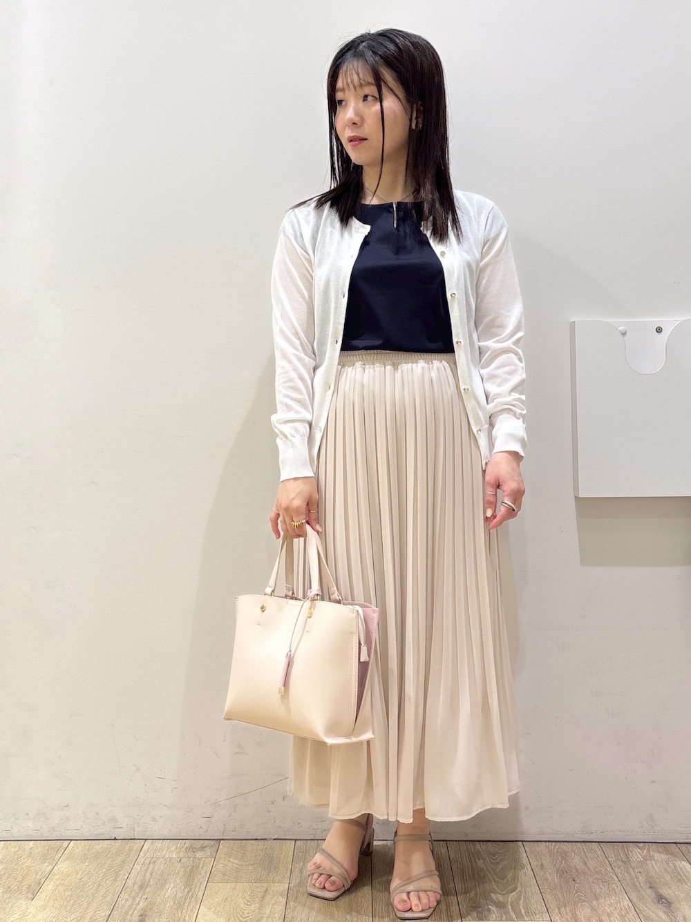 ホワイト系のカーディガン/ボレロ、ブルー系のTシャツ/カットソー、ベージュ系のスカートを着用したレディースの春コーディネートの1枚目の写真