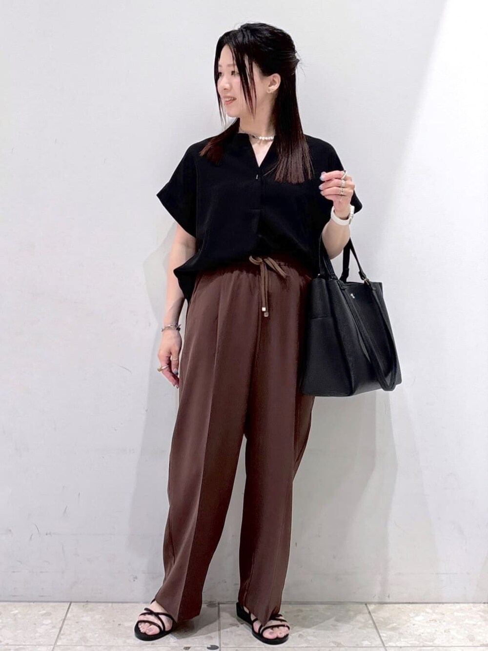 ブラック系のシャツ/ブラウス、ブラウン系のその他パンツ、ブラック系のトートバッグを着用したレディースの夏コーディネートの1枚目の写真