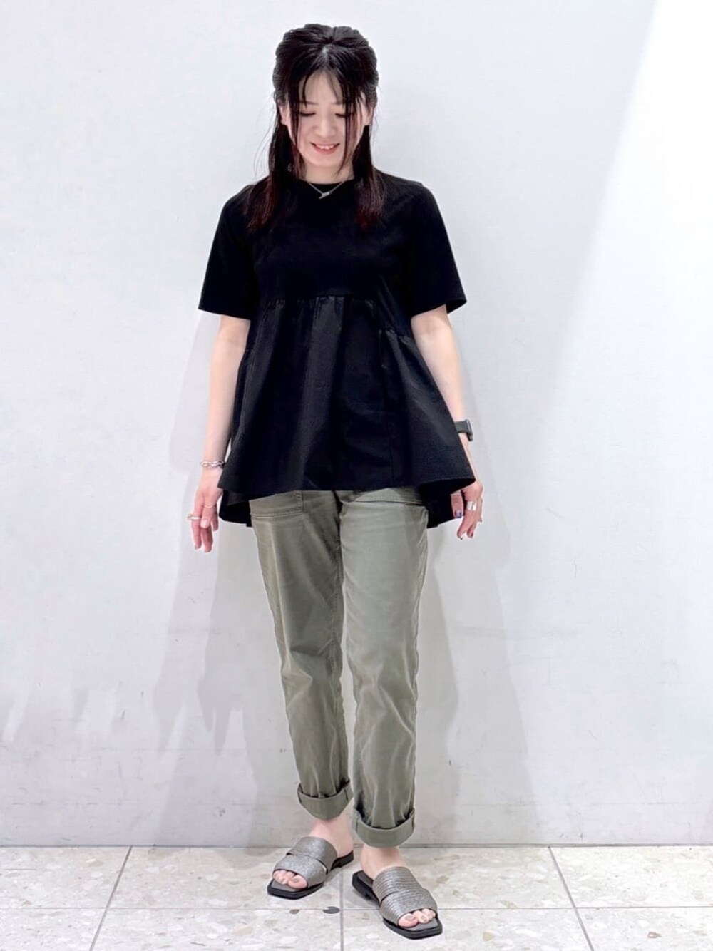 ブラック系のTシャツ/カットソー、グリーン系のその他パンツ、シルバー系のサンダルを着用したレディースの春コーディネートの1枚目の写真
