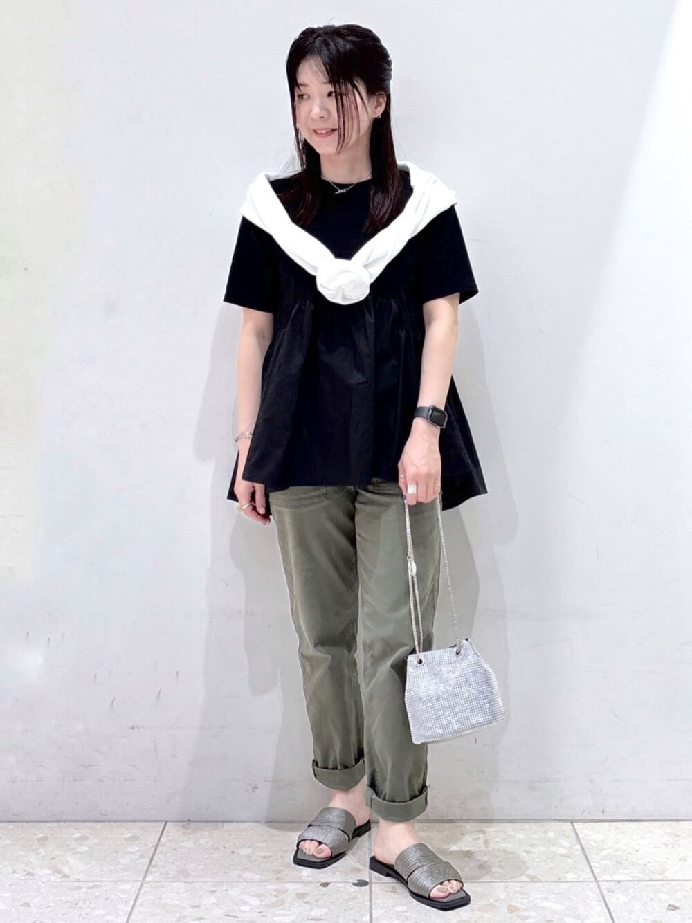 ブラック系のTシャツ/カットソー、ホワイト系のカーディガン/ボレロ、グリーン系のその他パンツを着用したレディースの春コーディネートの1枚目の写真