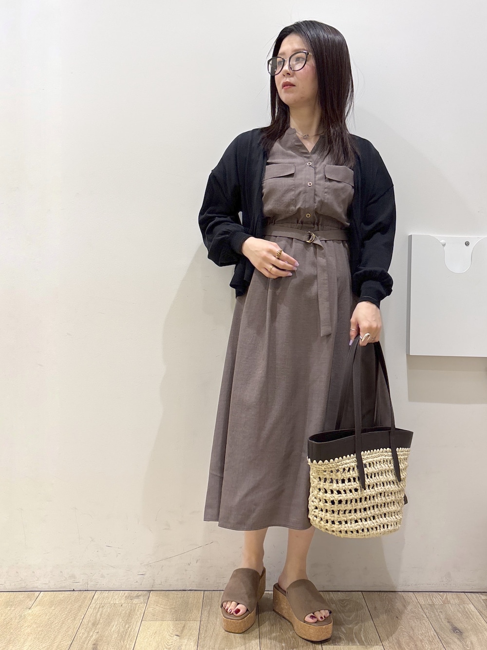 ブラウン系のワンピース、ブラウン系のトートバッグ、ベージュ系のサンダルを着用したレディースの夏コーディネートの1枚目の写真