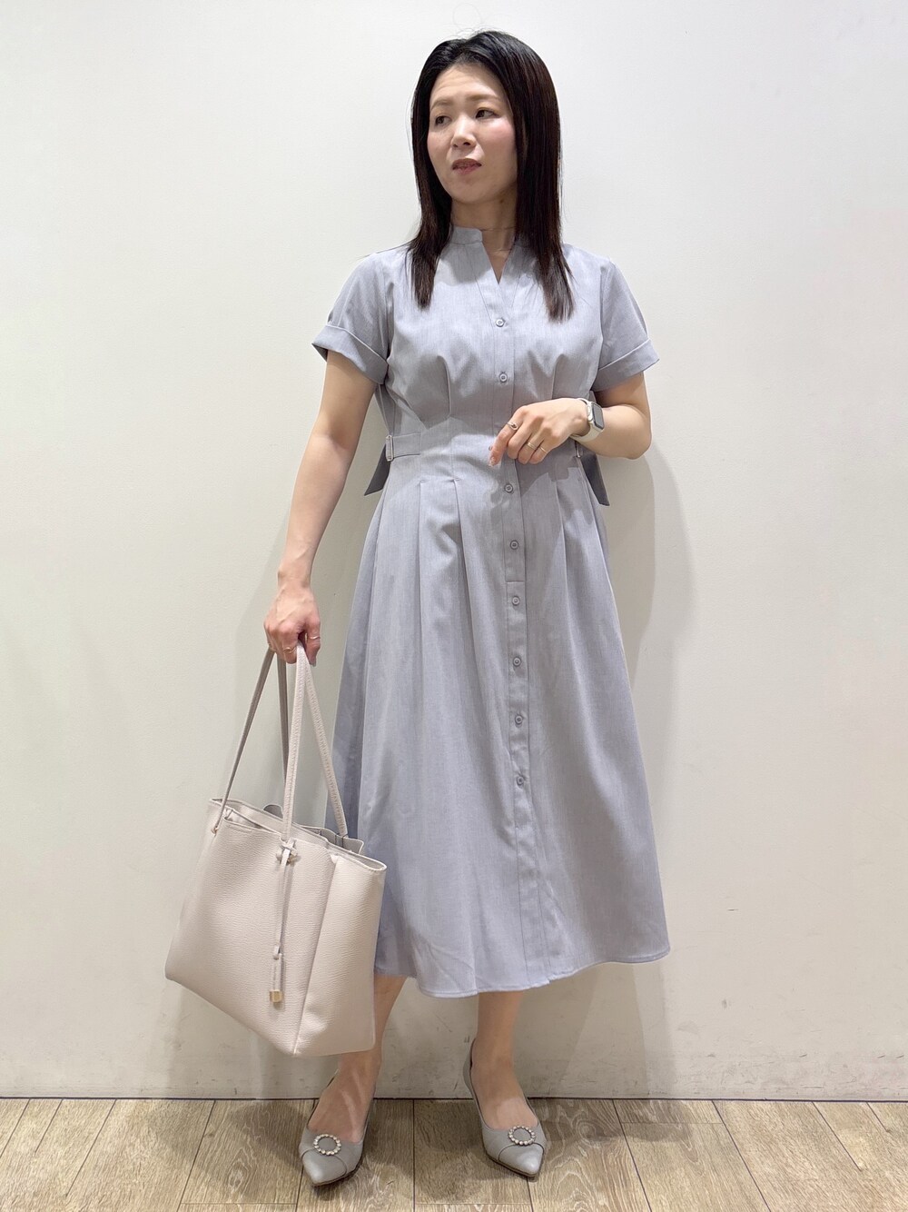グレー系のワンピース、グレー系のトートバッグ、グレー系のパンプスを着用したレディースの夏コーディネートの1枚目の写真