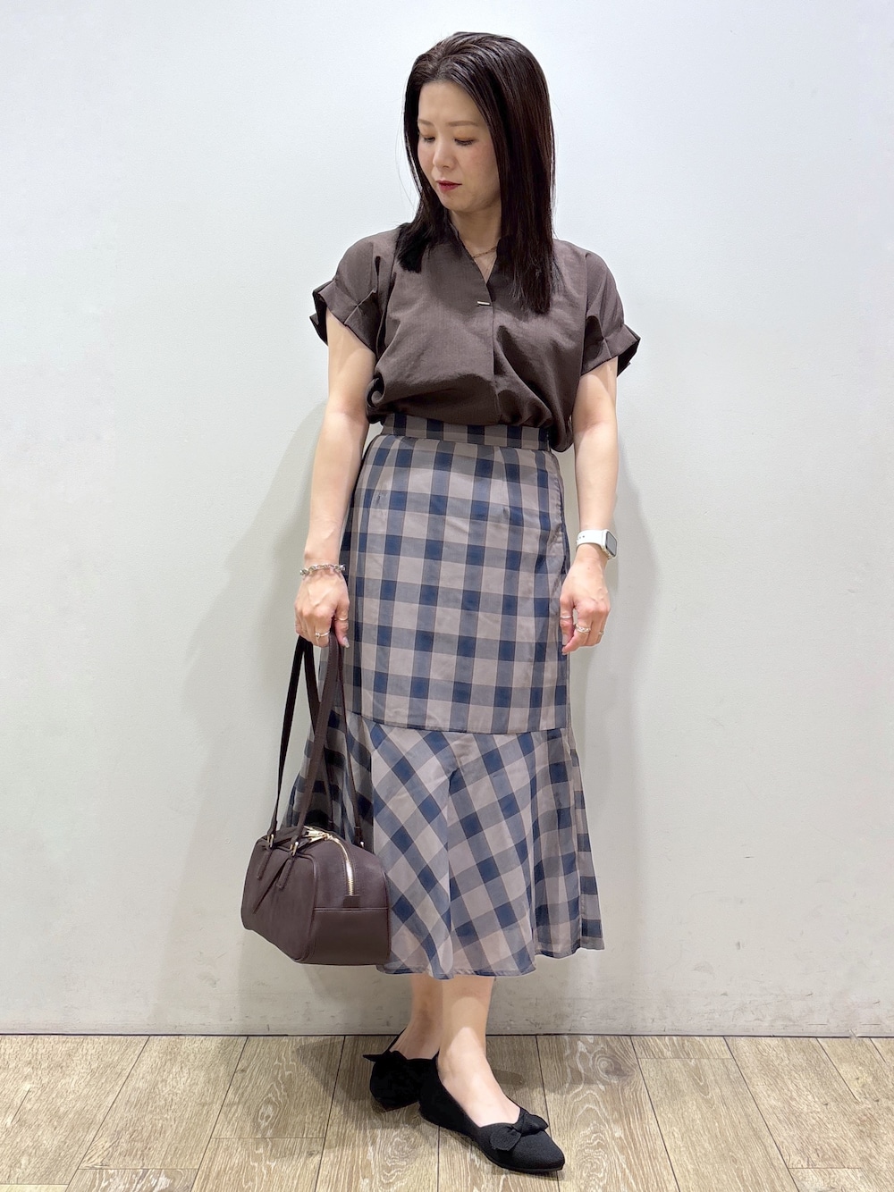 ブラウン系のシャツ/ブラウス、ブラウン系のスカート、レッド系のボストンバッグを着用したレディースの夏コーディネートの1枚目の写真