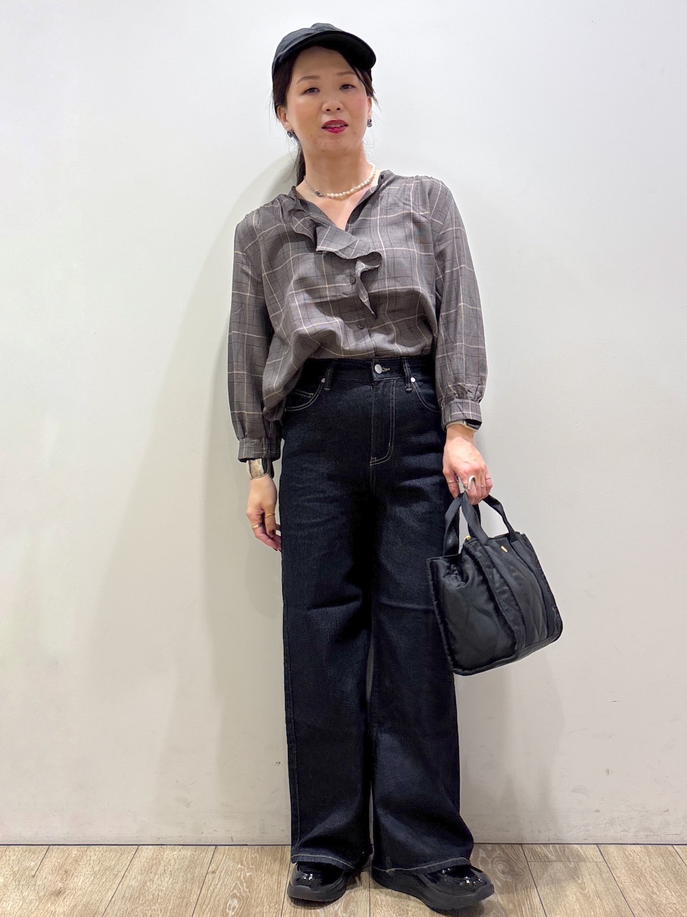 グレー系のシャツ/ブラウス、ブルー系のデニムパンツ、ブラック系のトートバッグを着用したレディースの秋コーディネートの1枚目の写真