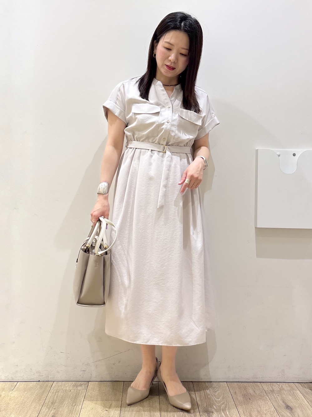 ベージュ系のワンピース、ベージュ系のトートバッグ、ベージュ系のパンプスを着用したレディースの夏コーディネートの1枚目の写真