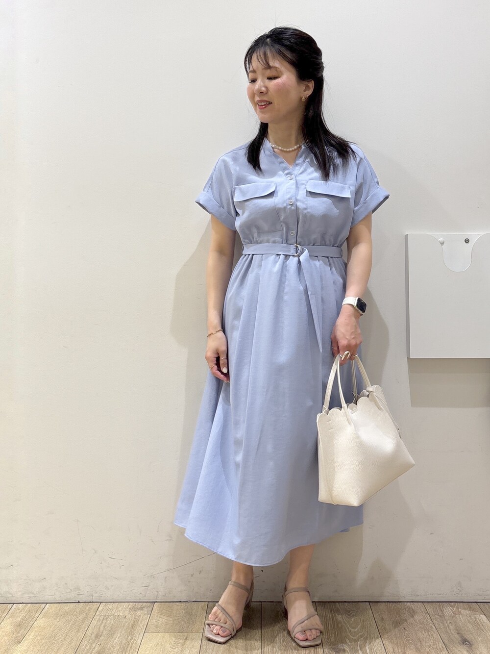 ブルー系のワンピース、ホワイト系のトートバッグ、ベージュ系のサンダルを着用したレディースの春コーディネートの1枚目の写真