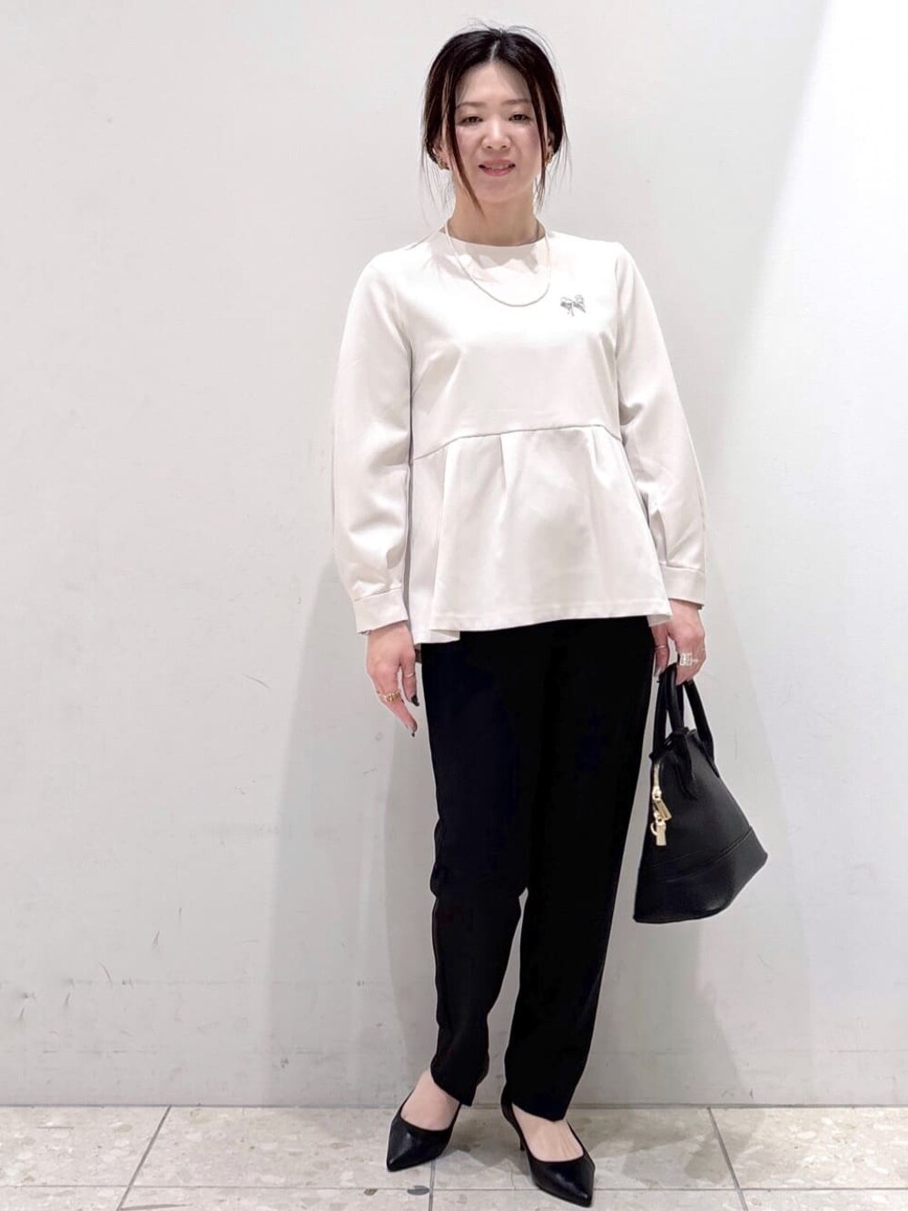 ベージュ系のシャツ/ブラウス、ブラック系のその他パンツ、ブラック系のハンドバッグを着用したレディースの冬コーディネートの1枚目の写真