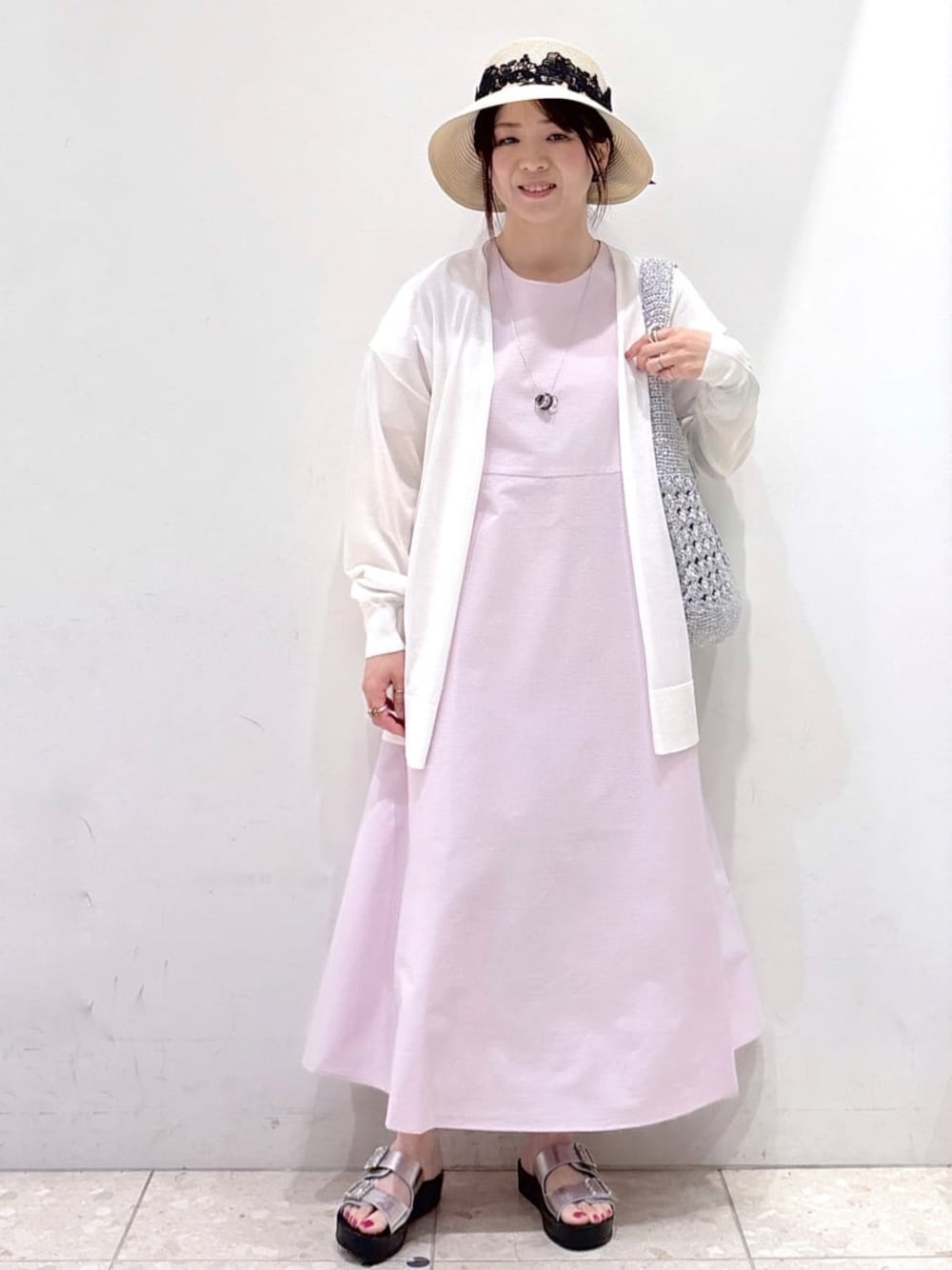 ホワイト系のカーディガン/ボレロ、ピンク系のワンピース、シルバー系のショルダーバッグを着用したレディースの夏コーディネートの1枚目の写真