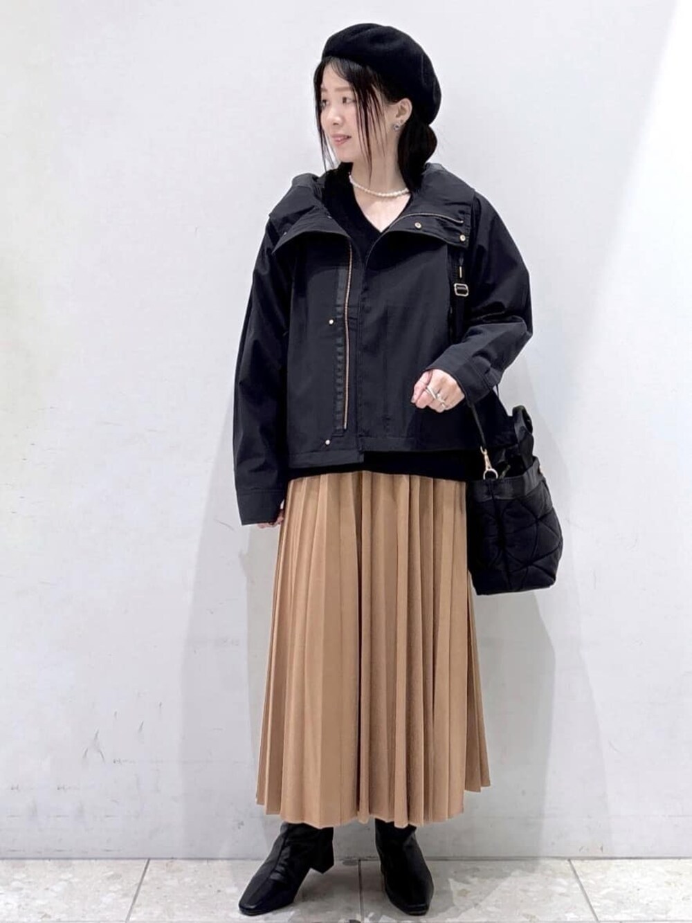 ブラック系のニット/セーター、イエロー系のスカート、ブラック系のトートバッグを着用したレディースの秋コーディネートの1枚目の写真