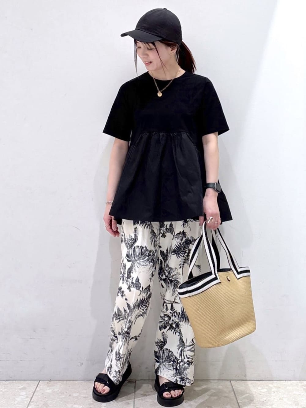 ブラック系のTシャツ/カットソー、ベージュ系のその他パンツ、ベージュ系のトートバッグを着用したレディースの春コーディネートの1枚目の写真