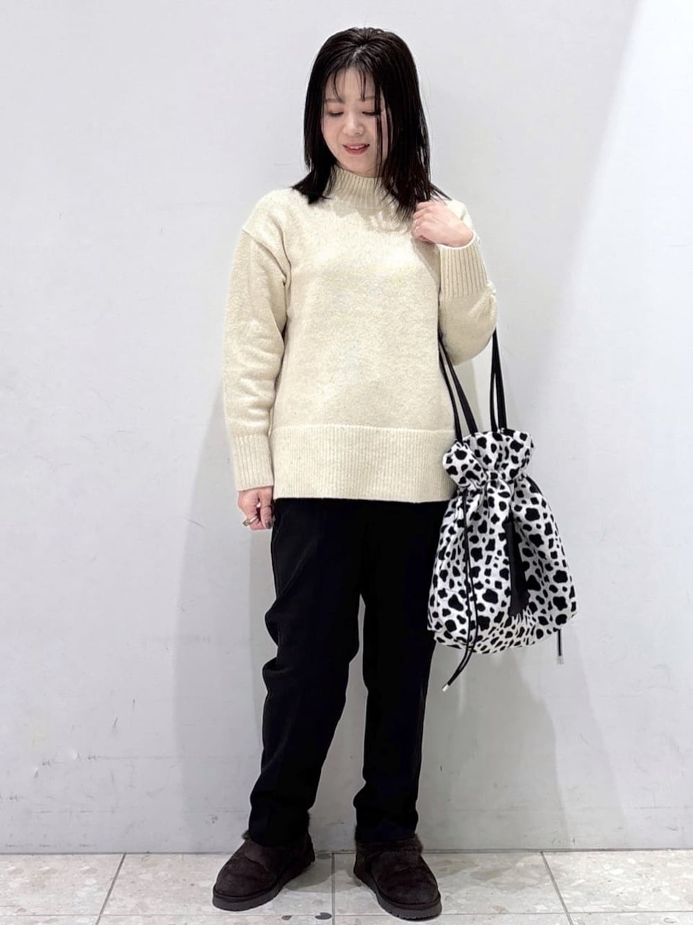 ベージュ系のニット/セーター、ブラック系のその他パンツ、ブラック系のトートバッグを着用したレディースの冬コーディネートの1枚目の写真