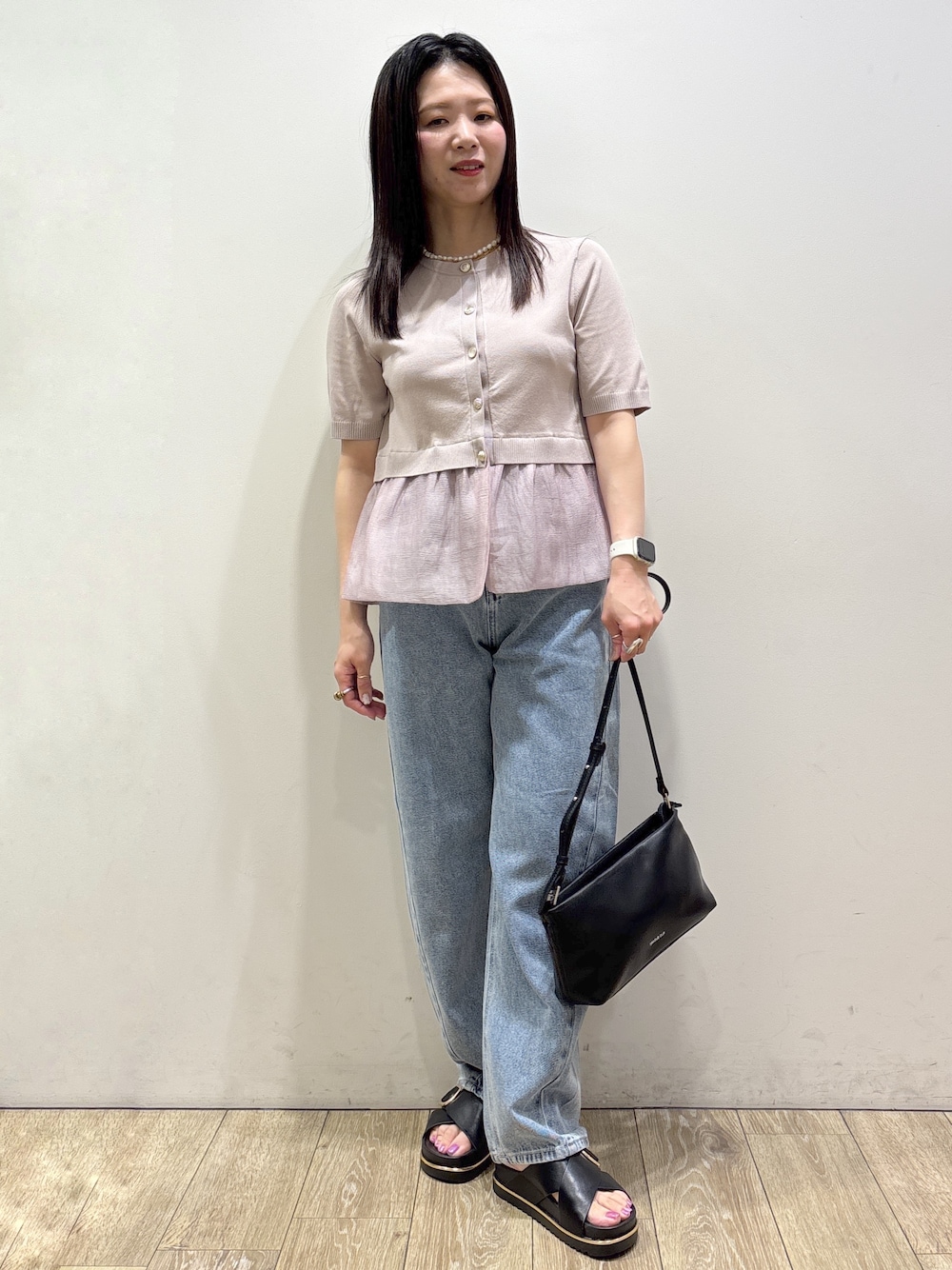 ベージュ系のカーディガン/ボレロ、ブルー系のデニムパンツ、ブラック系のショルダーバッグを着用したレディースの夏コーディネートの1枚目の写真