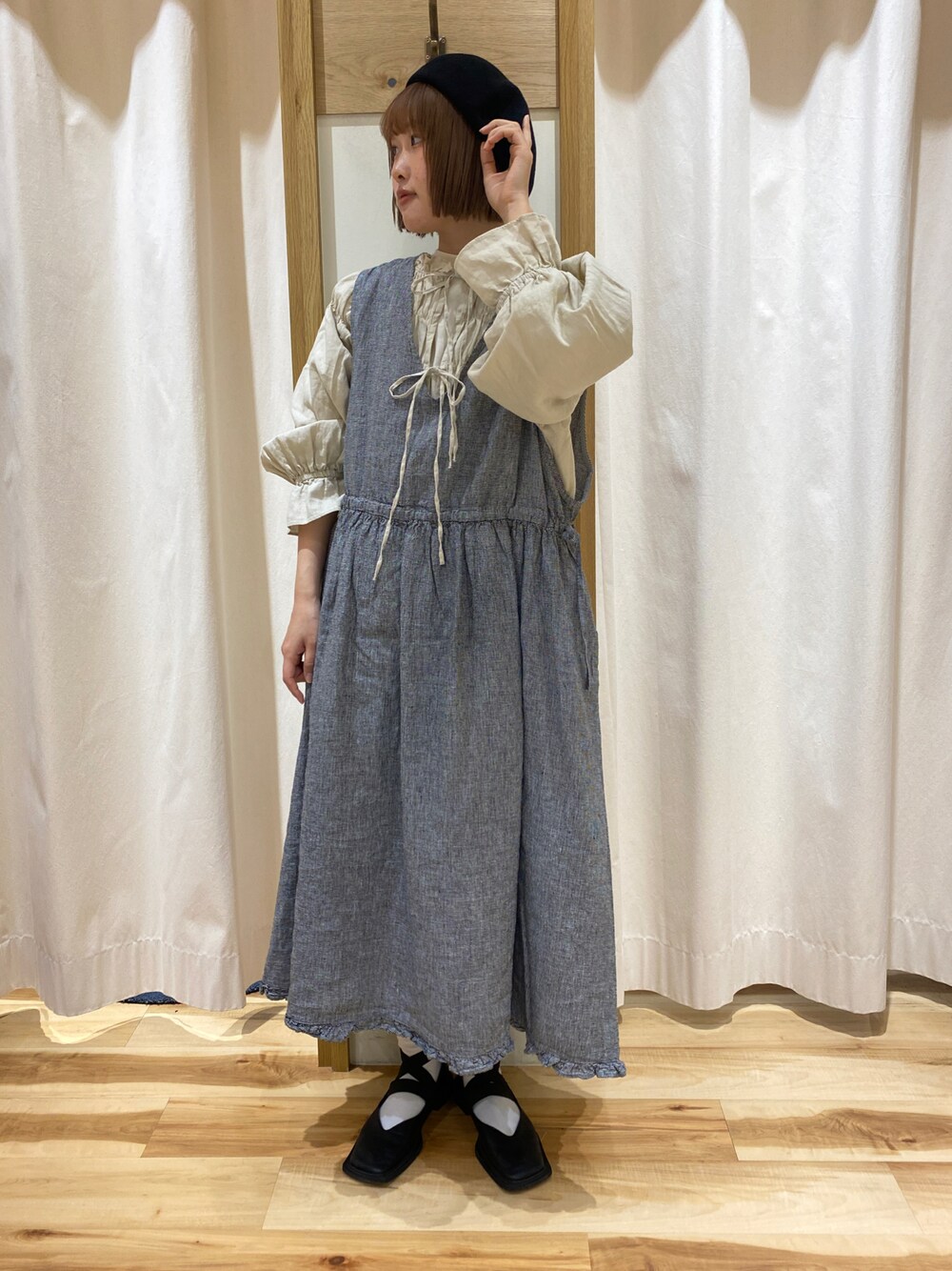 ブラック系のワンピース、ベージュ系のトップス、ホワイト系のTシャツ/カットソーを着用したレディースの春コーディネートの1枚目の写真