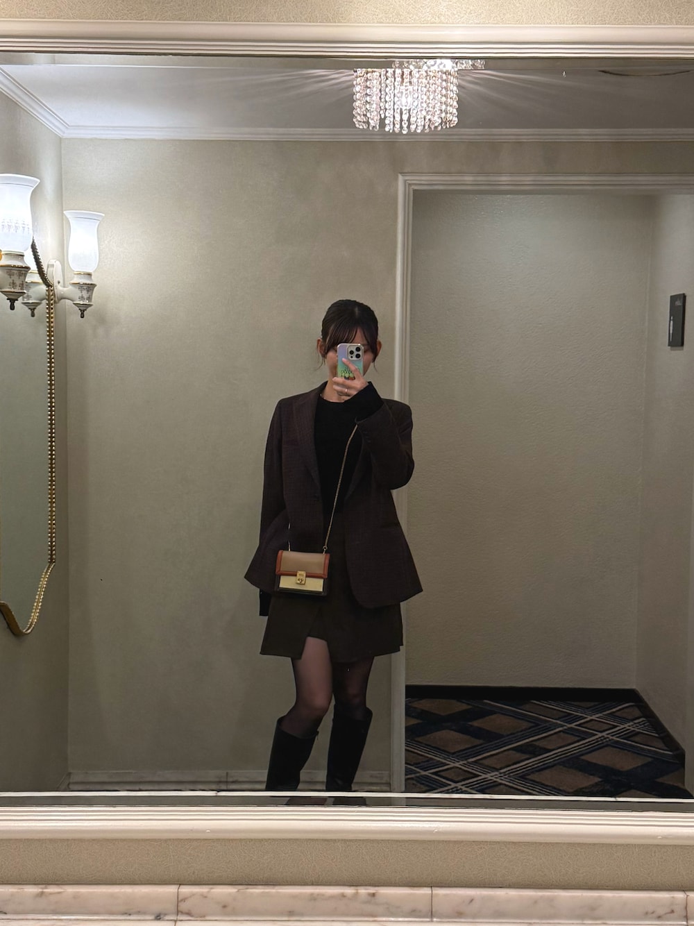 ブラウン系のテーラードジャケット、ブラウン系のショルダーバッグ、ブラック系のブーツを着用したレディースの秋コーディネートの1枚目の写真