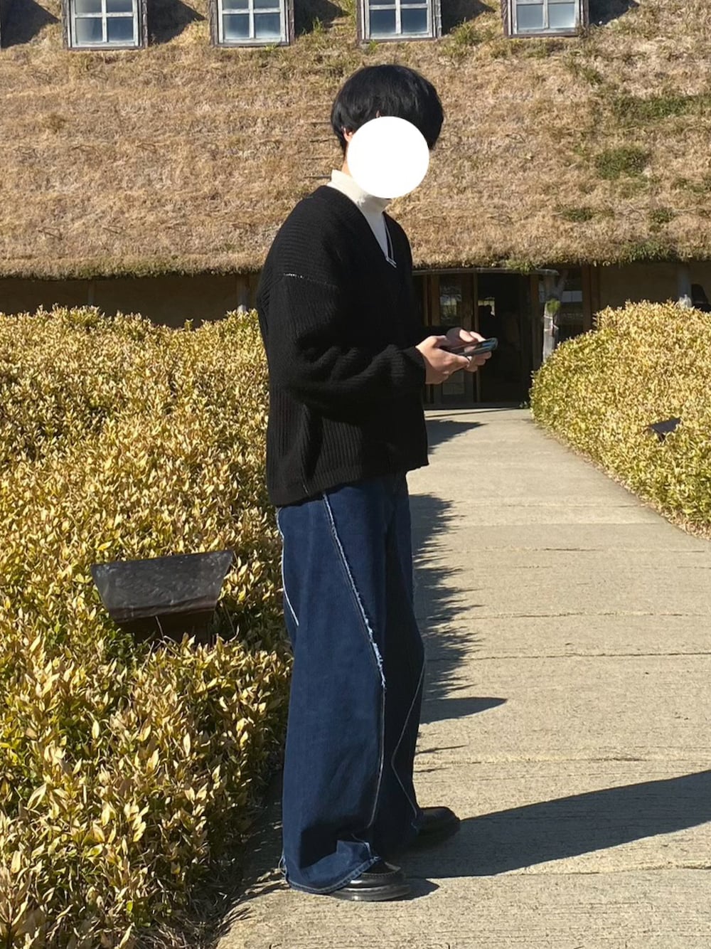 ブラック系のローファー、ブルー系のデニムパンツ、ブラック系のニット/セーターを着用したメンズの冬コーディネートの1枚目の写真