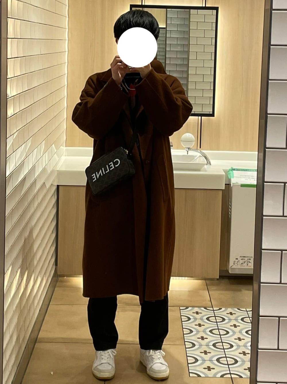 ホワイト系のスニーカー、ブラック系のパンツ、ブラウン系のその他アウターを着用したメンズの冬コーディネートの1枚目の写真