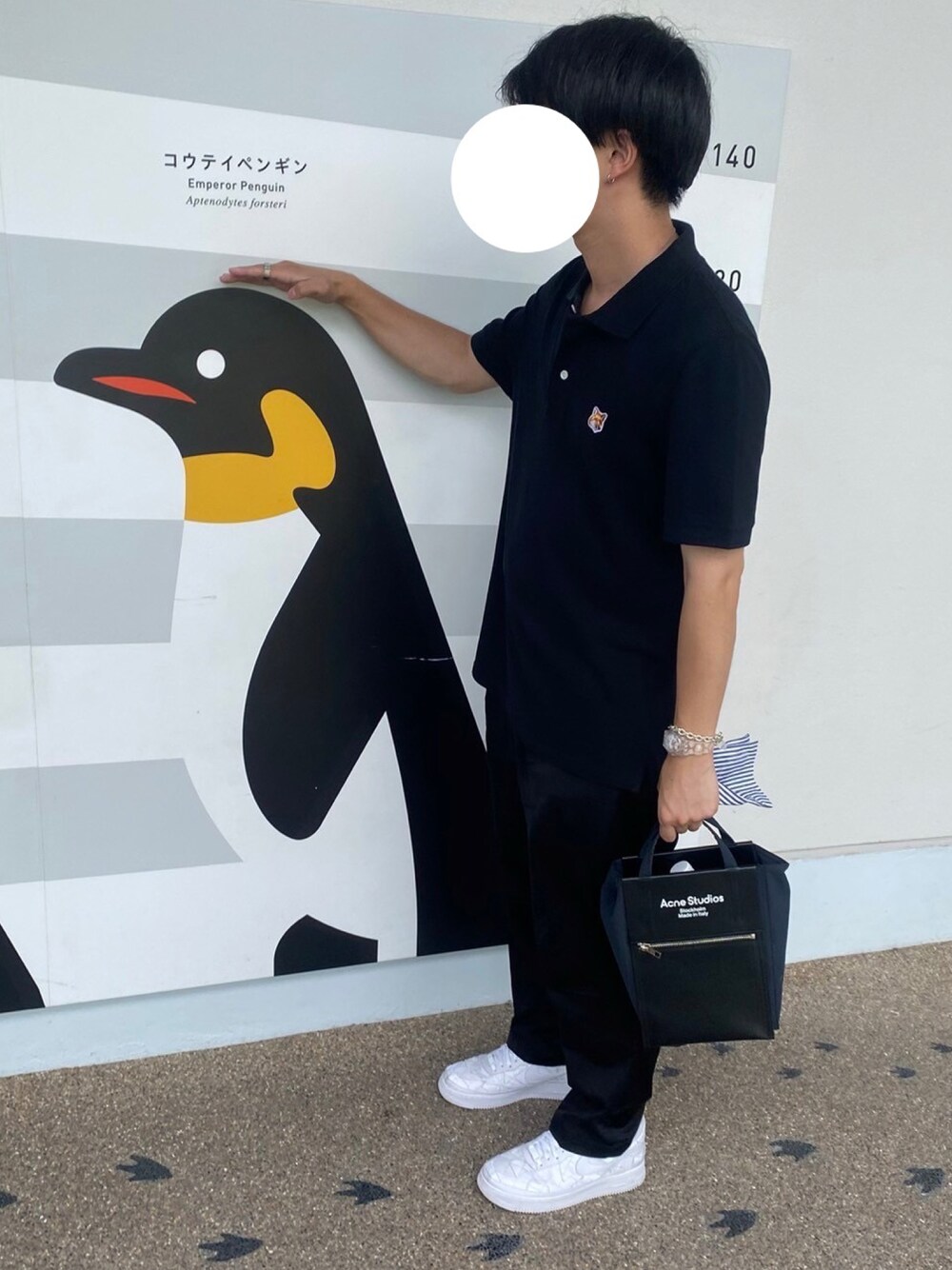 ブラック系のポロシャツ、ブラック系のバッグ、ブラック系のパンツを着用したメンズの夏コーディネートの1枚目の写真