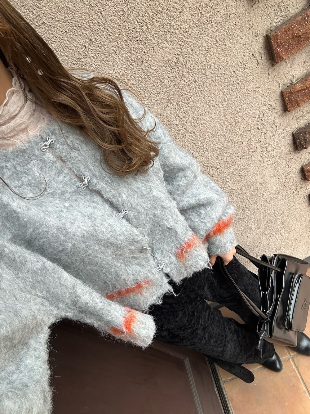 グレー系のニット/セーター、ブラック系のその他パンツ、ブラック系のショルダーバッグを着用したレディースの春コーディネートの1枚目の写真