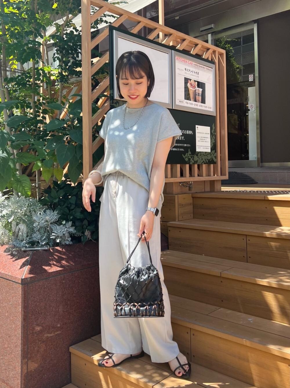 グレー系のニット/セーター、グレー系のその他パンツ、ホワイト系のバングル/リストバンドを着用したレディースの夏コーディネートの1枚目の写真