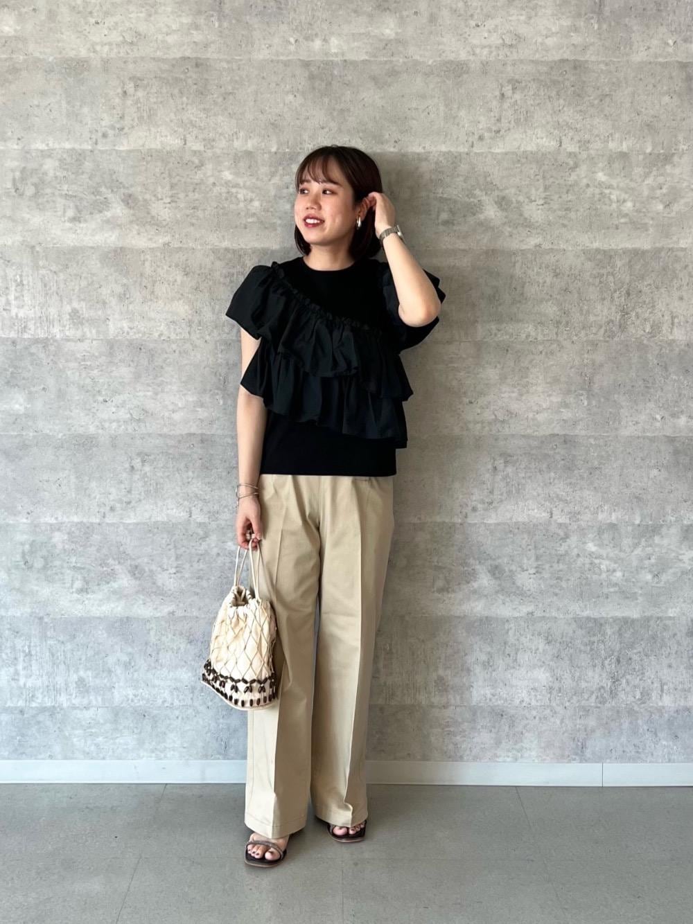 ベージュ系のその他パンツ、ブラック系のサンダル、ホワイト系のショルダーバッグを着用したレディースの夏コーディネートの1枚目の写真