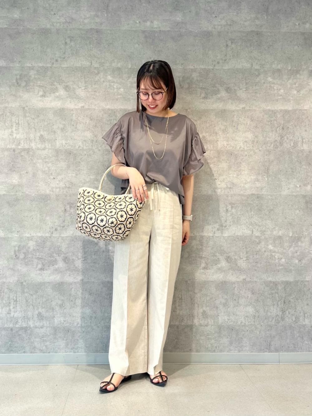 ベージュ系のその他パンツ、ベージュ系のトートバッグ、ブラウン系のTシャツ/カットソーを着用したレディースの春コーディネートの1枚目の写真