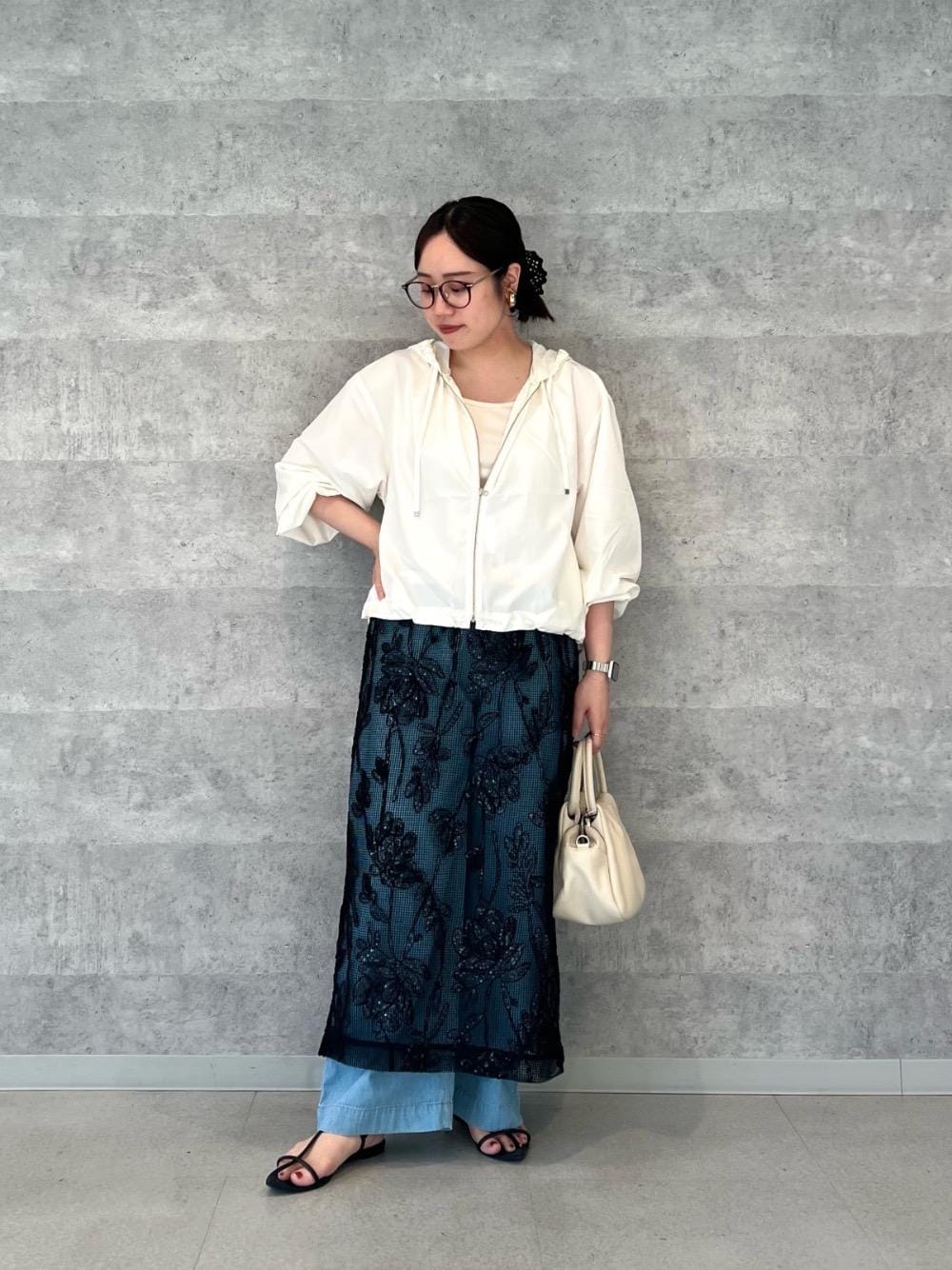 ブルー系のデニムパンツ、ベージュ系のタンクトップ、ブラック系のスカートを着用したレディースの夏コーディネートの1枚目の写真