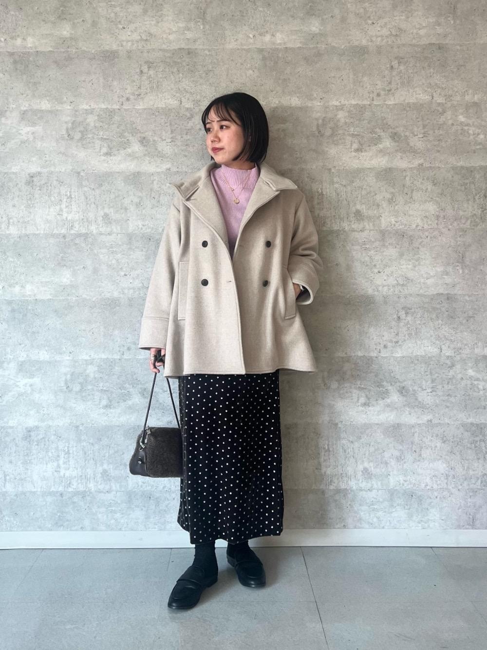 パープル系のニット/セーター、ブラウン系のスカート、ブラウン系のショルダーバッグを着用したレディースの冬コーディネートの1枚目の写真