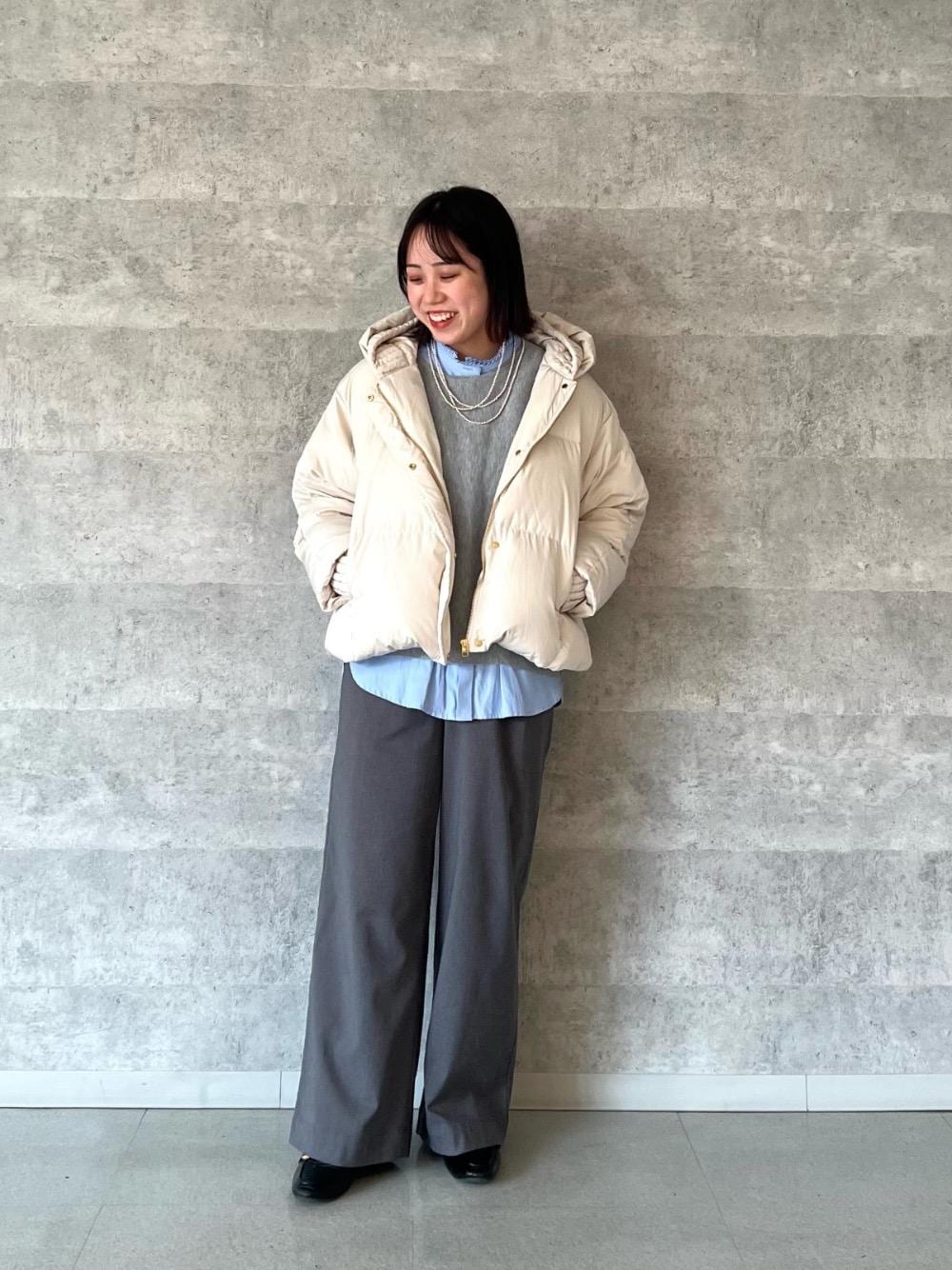 ブルー系のシャツ/ブラウス、ベージュ系のダウンジャケット/コート、グレー系のニット/セーターを着用したレディースの冬コーディネートの1枚目の写真