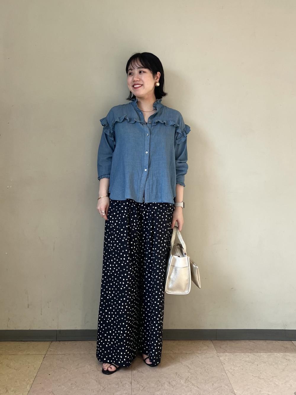 ゴールド系のトートバッグ、ブルー系のシャツ/ブラウス、ブルー系のその他パンツを着用したレディースの夏コーディネートの1枚目の写真