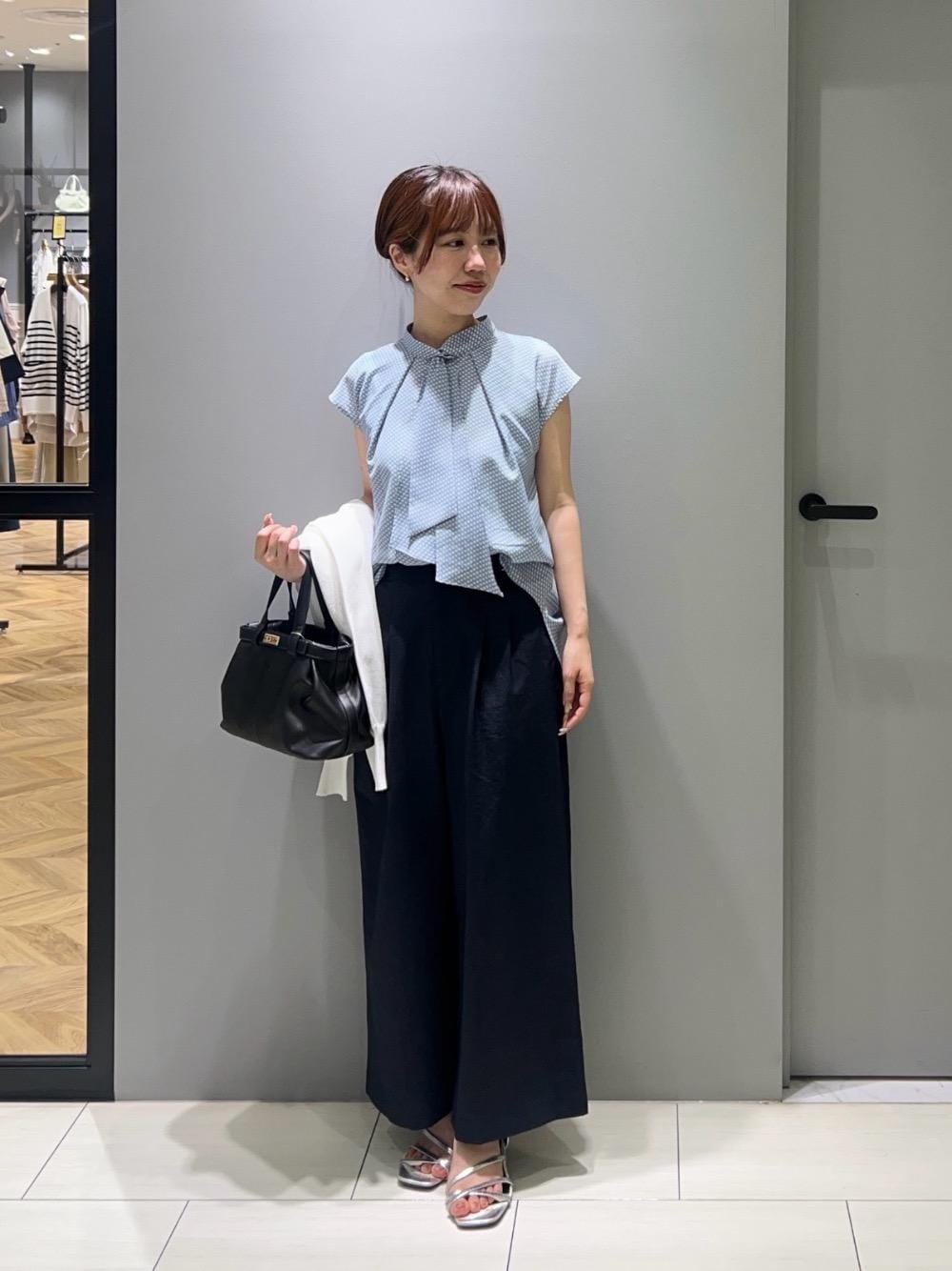 ブラック系のトートバッグ、ブルー系のその他パンツ、ホワイト系のパーカーを着用したレディースの春コーディネートの1枚目の写真