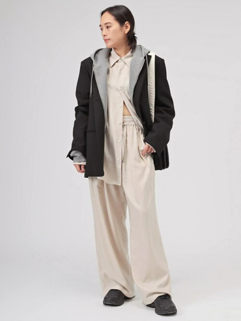 ベージュ系のシャツ/ブラウス、ベージュ系のその他パンツ、ブラック系のその他アウターを着用したレディースの冬コーディネートの1枚目の写真