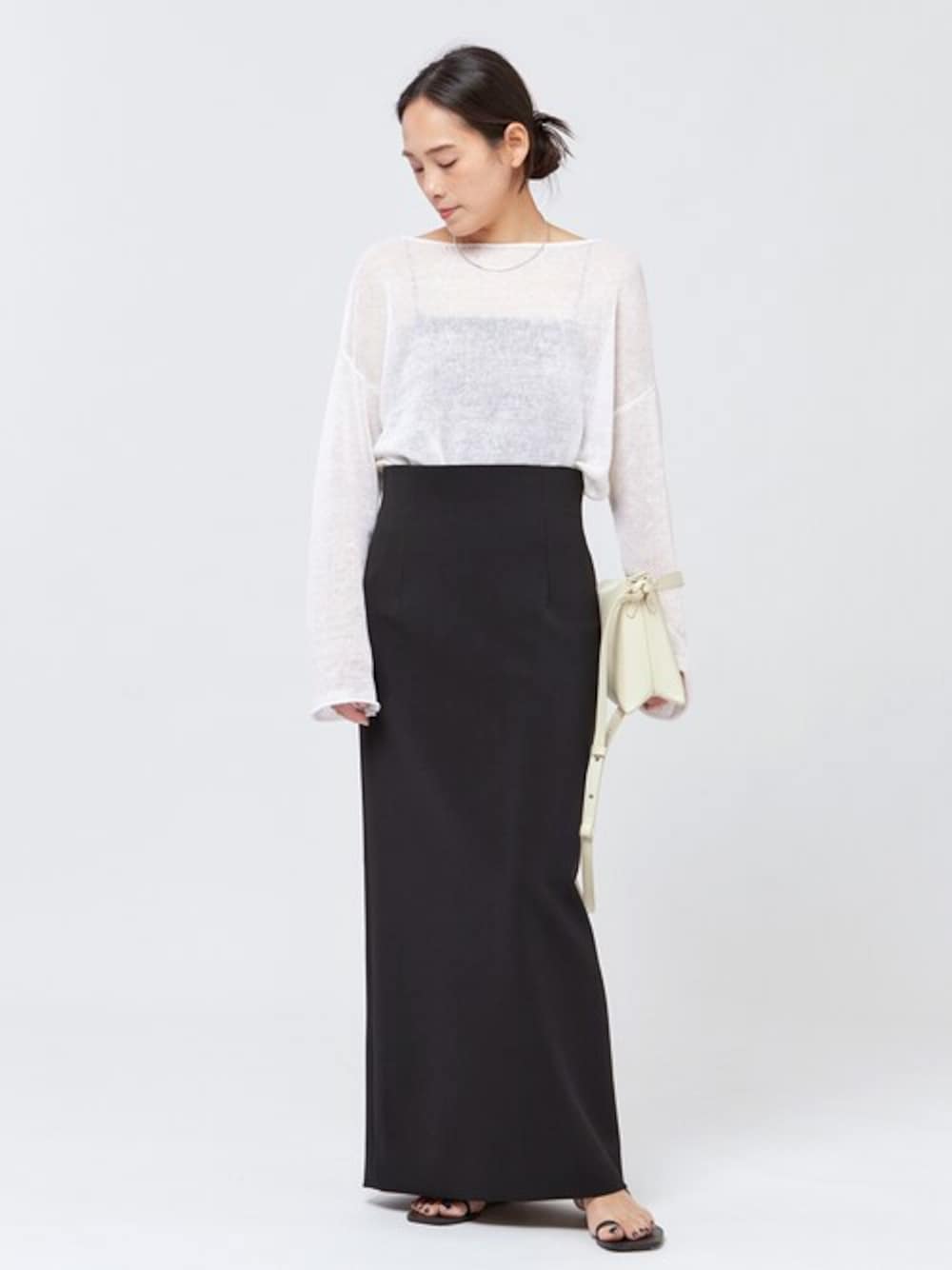 ホワイト系のニット/セーター、ホワイト系のショルダーバッグ、ブラック系のその他アンダーウェア/インナーを着用したレディースの春コーディネートの1枚目の写真