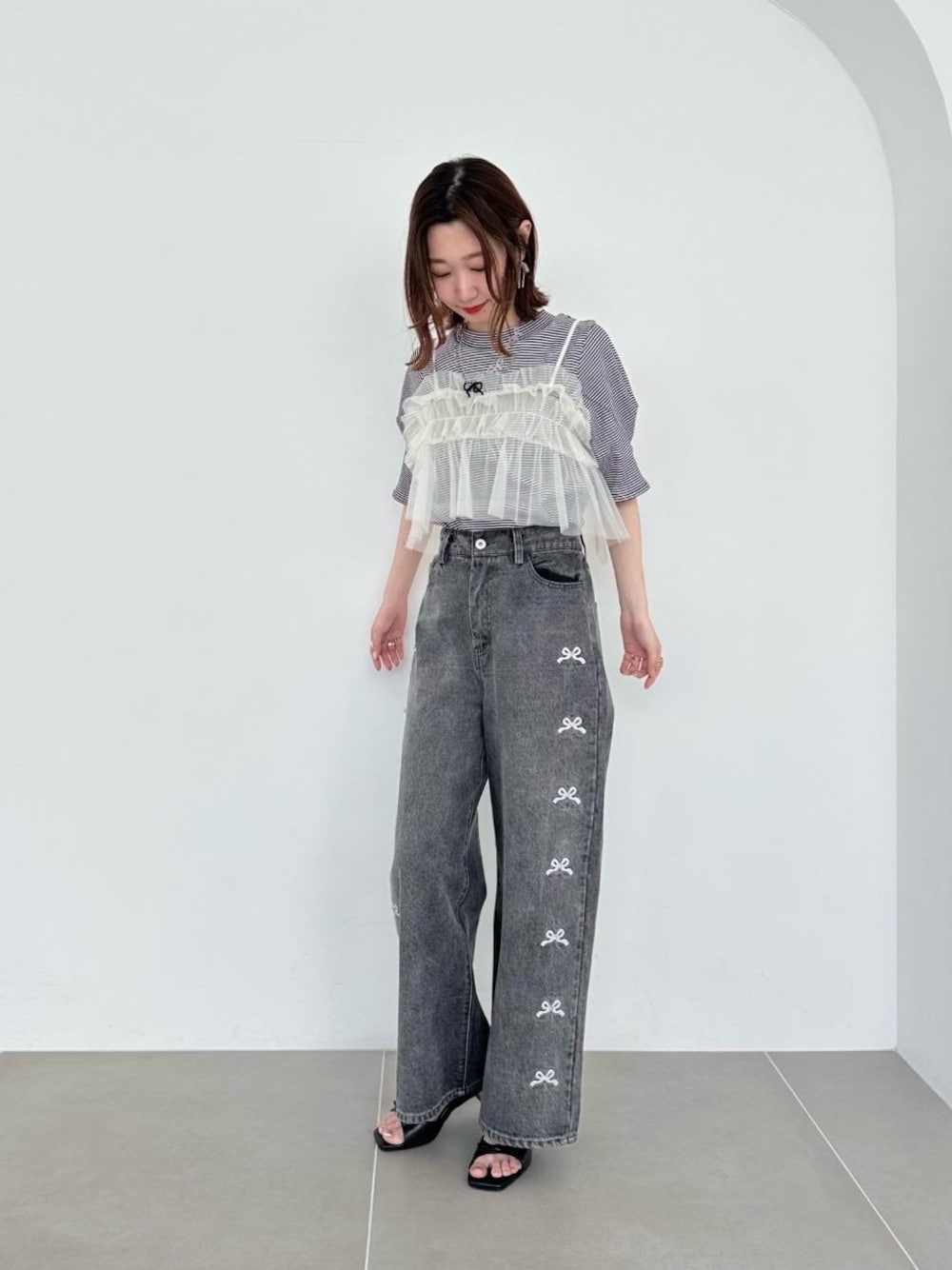 ブラック系のサンダル、ホワイト系のシャツ/ブラウス、ブラック系のTシャツ/カットソーを着用したレディースの春コーディネートの1枚目の写真