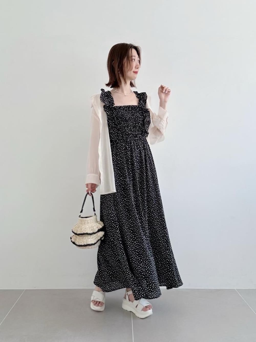 ホワイト系のサンダル、ホワイト系のハンドバッグ、ホワイト系のシャツ/ブラウスを着用したレディースの春コーディネートの1枚目の写真