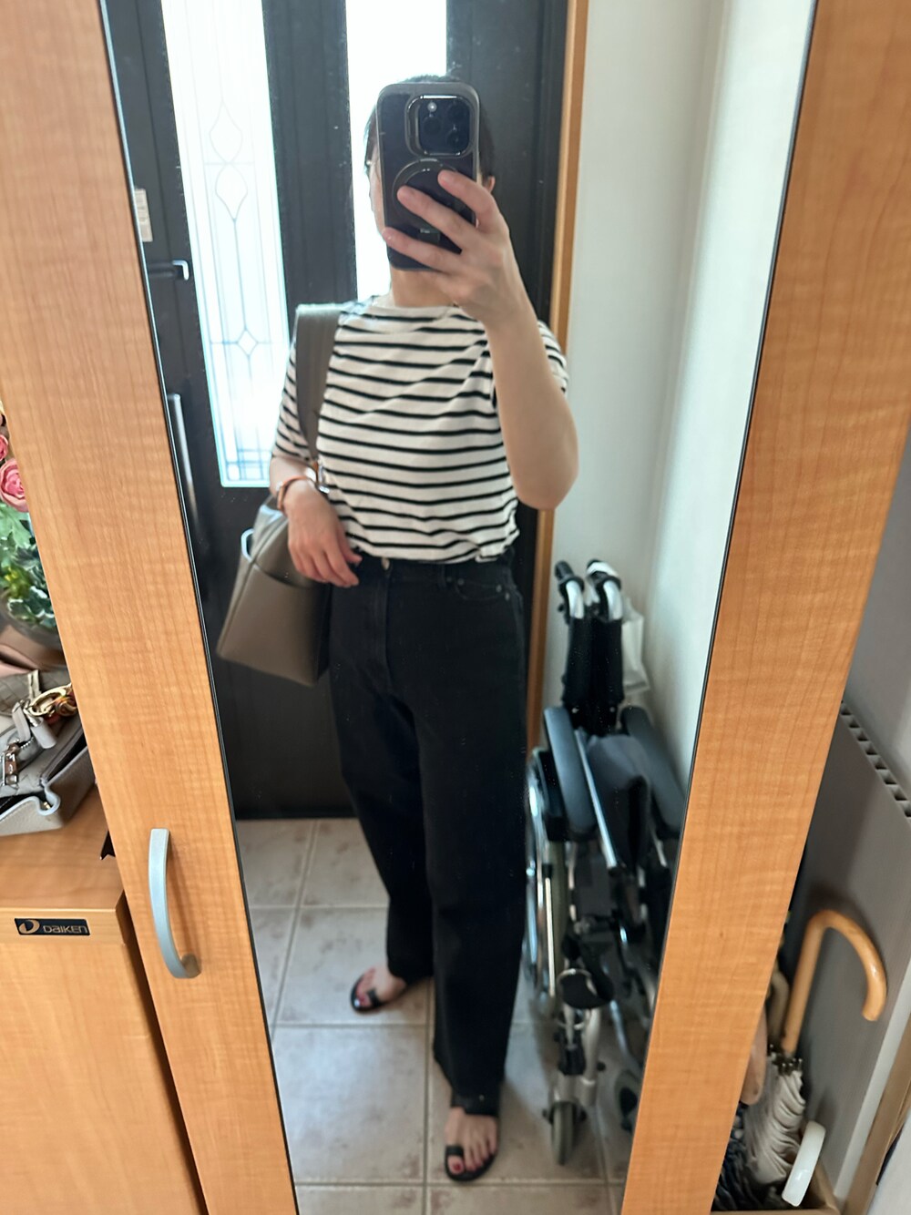 ブラック系のTシャツ/カットソー、ブラック系のデニムパンツ、ブラック系のサンダルを着用したレディースの夏コーディネートの1枚目の写真