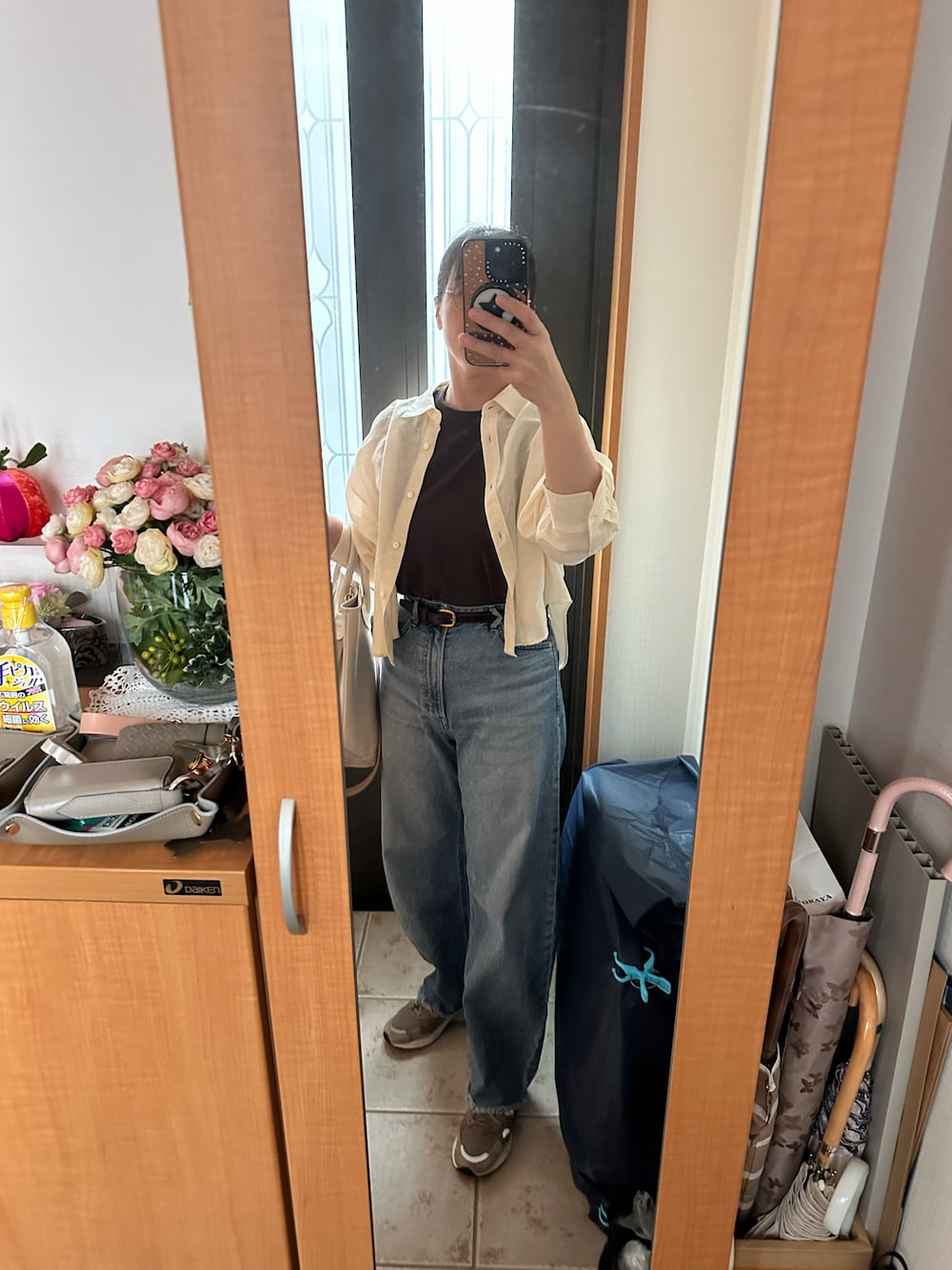 ブラウン系のタンクトップ、ベージュ系のシャツ/ブラウス、ブルー系のデニムパンツを着用したレディースの秋コーディネートの1枚目の写真