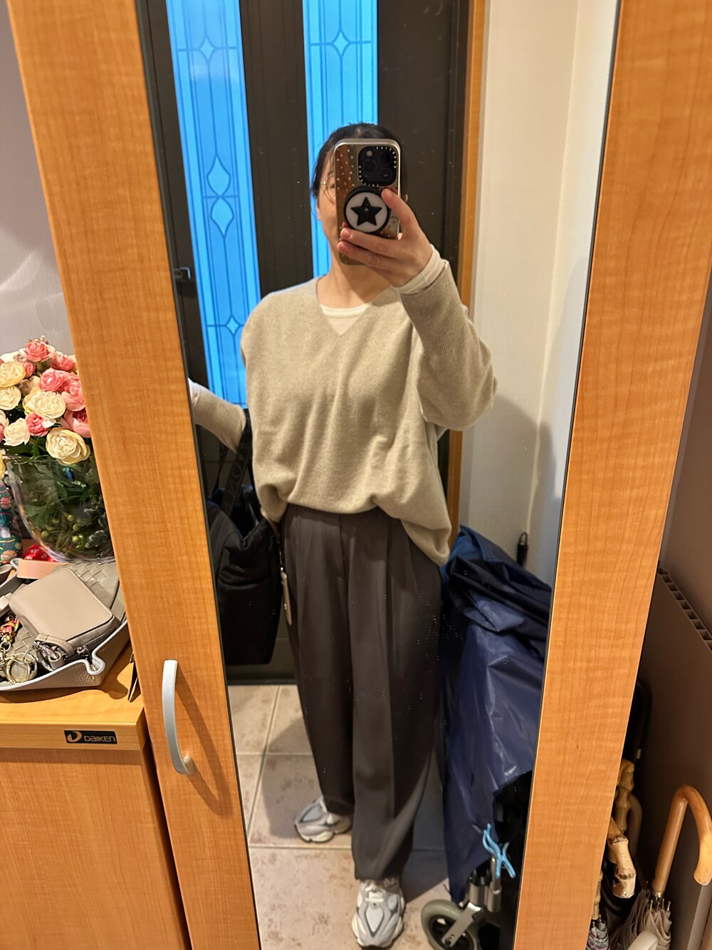 ベージュ系のニット/セーター、ホワイト系のTシャツ/カットソー、ブラック系のトートバッグを着用したレディースの冬コーディネートの1枚目の写真