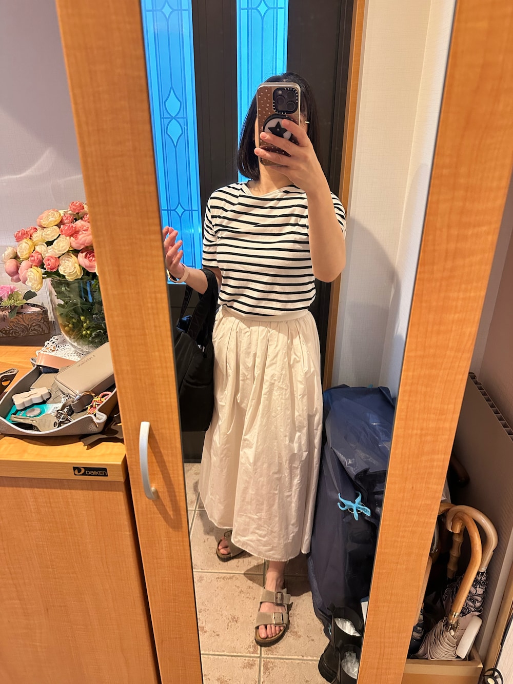 ブラック系のTシャツ/カットソー、ホワイト系のスカート、その他のシューズを着用したレディースの秋コーディネートの1枚目の写真