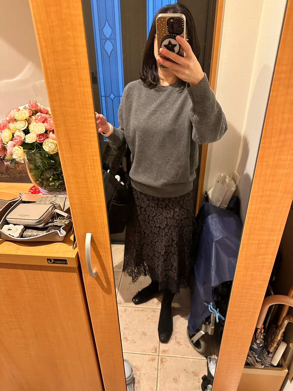 グレー系のニット/セーター、ベージュ系のダウンジャケット/コート、ブラック系のシューズを着用したレディースの冬コーディネートの1枚目の写真