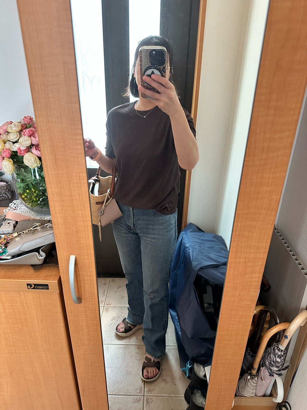 ブラウン系のTシャツ/カットソー、ブルー系のデニムパンツ、ブラウン系のサンダルを着用したレディースの夏コーディネートの1枚目の写真