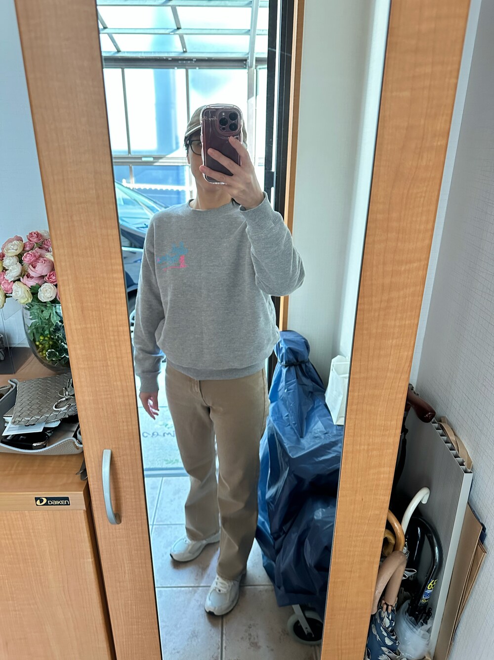 ベージュ系のデニムパンツ、ホワイト系のスニーカー、ベージュ系のキャップを着用したレディースの冬コーディネートの1枚目の写真