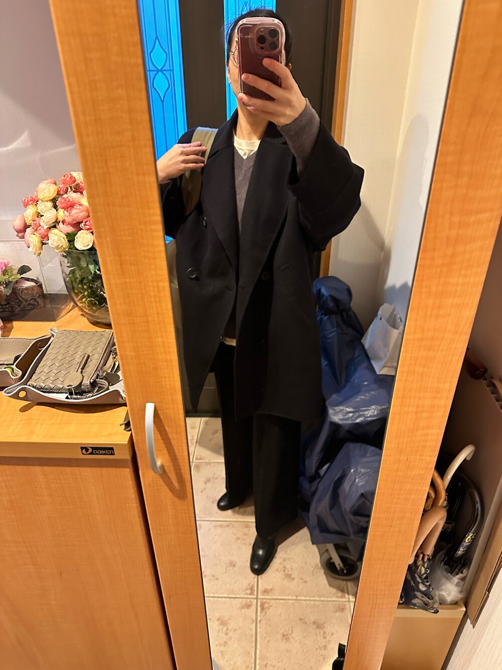 ブルー系のその他アウター、グレー系のニット/セーター、ブラック系のスラックスを着用したレディースの冬コーディネートの1枚目の写真