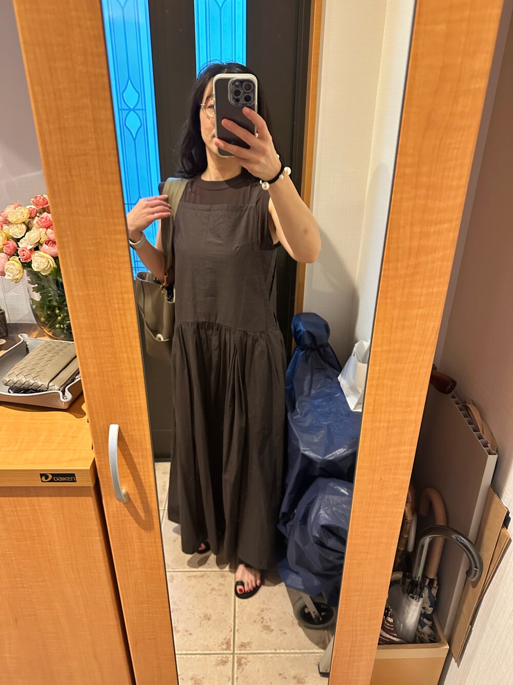 グレー系のワンピース、ブラウン系のタンクトップ、ブラック系のサンダルを着用したレディースの夏コーディネートの1枚目の写真